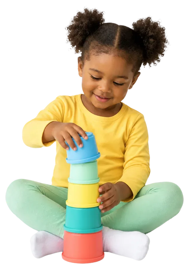 A toddler girl in a yellow shirt stacking colorful nesting cups